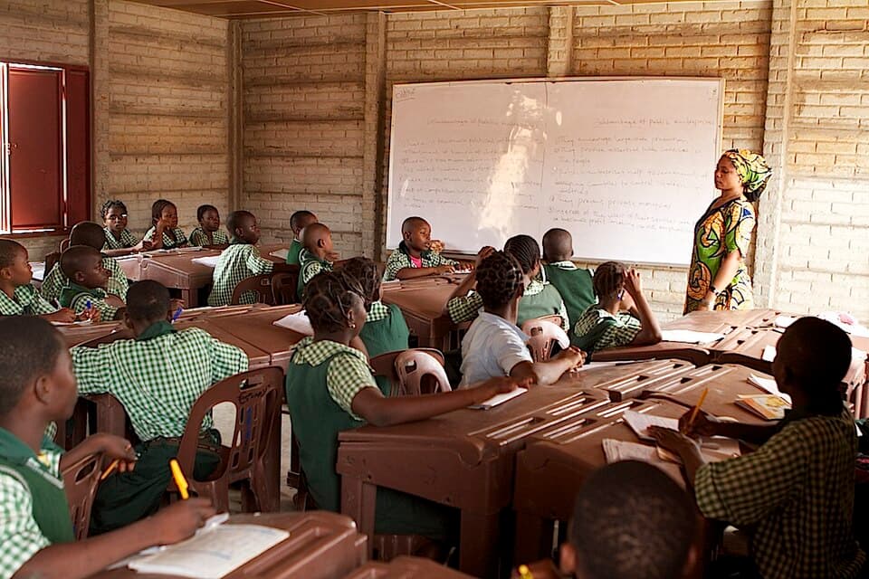 Teacher guiding learners in a Nigerian classroom